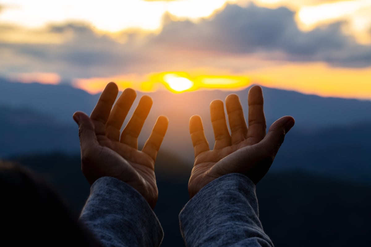 Manos cristianas orando sobre una Biblia abierta