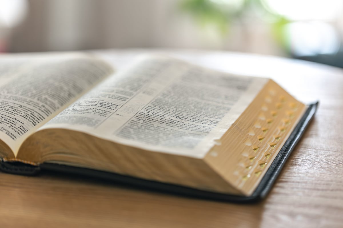Biblia abierta sobre una superficie de madera con luz natural
